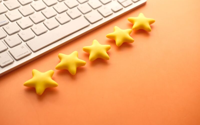 Customer review concept. Rating golden stars on orange background Customer review concept. Rating golden stars
